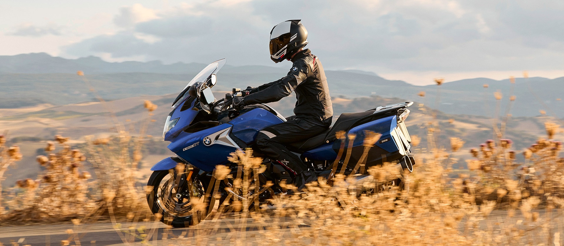 K 1600 GT в Style Sport на фона на местност със сухи треви по залез-слънце и в изглед отстрани.