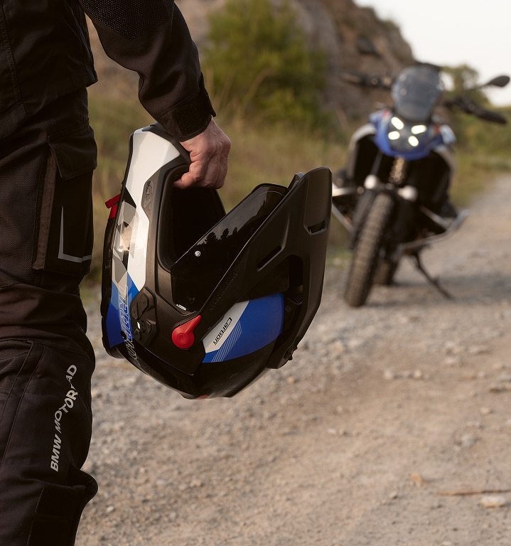 Човек държи мотоциклетна каска в ръката си.